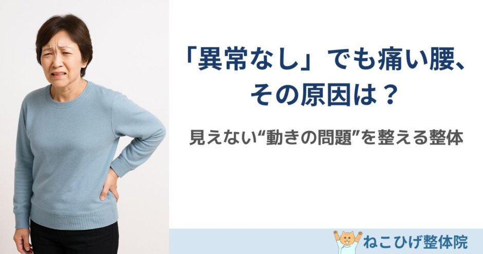日本人中年女性が腰を軽く押さえながら立ち上がる瞬間。背景は明るい診察室またはリビング。自然光。姿勢の硬さと不安が少し見える表情。